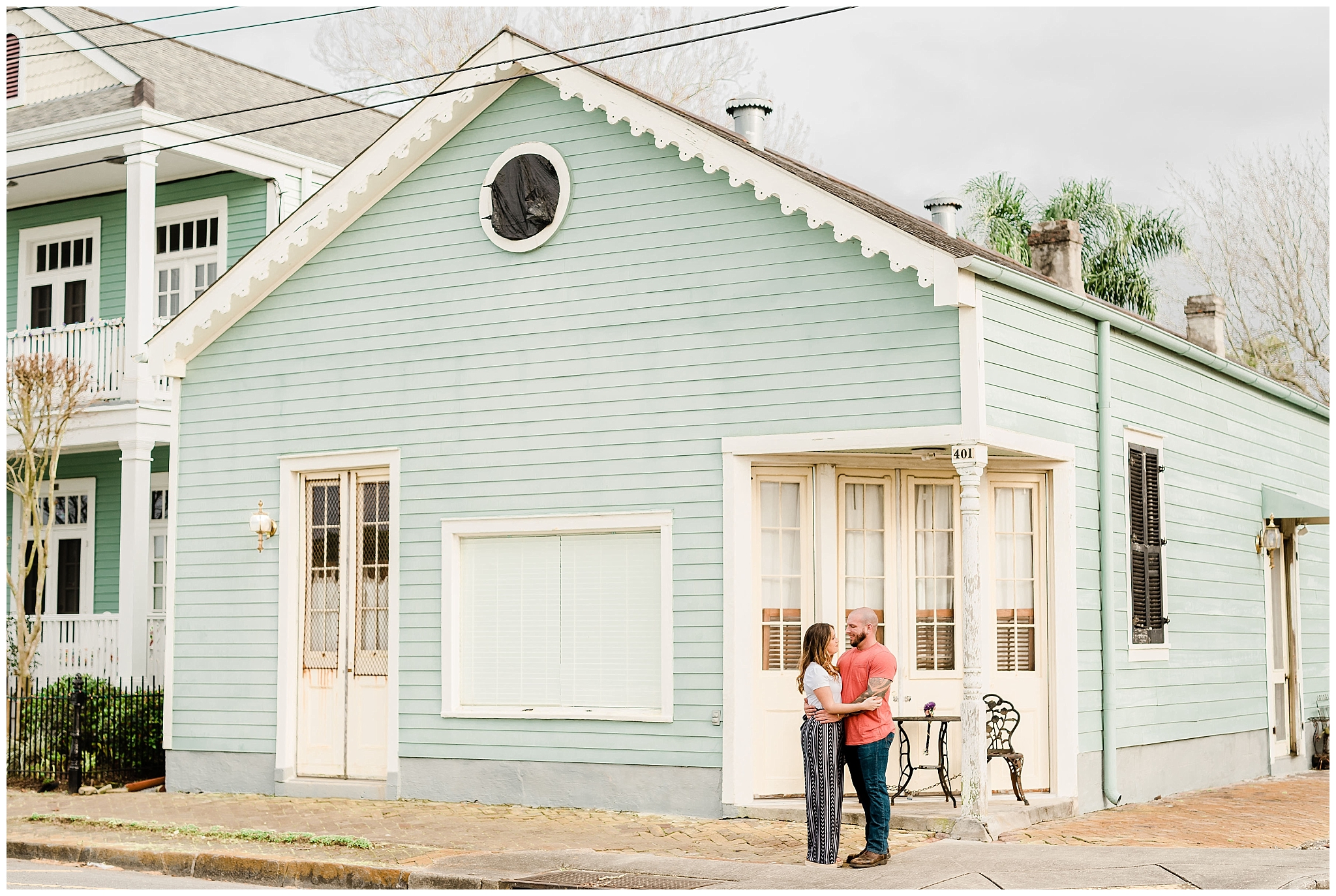 Couple stands near mint green building in downtown algiers new orleans